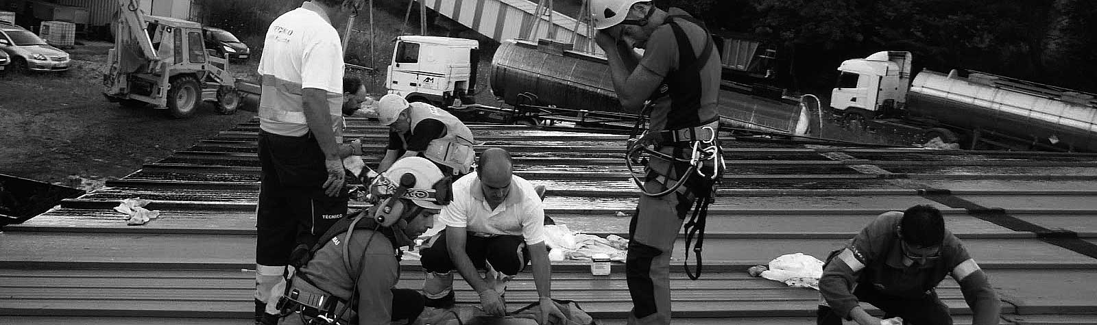 Grupo de personas atendiendo una situación de emergencia en una obra. Foto en blanco y negro.